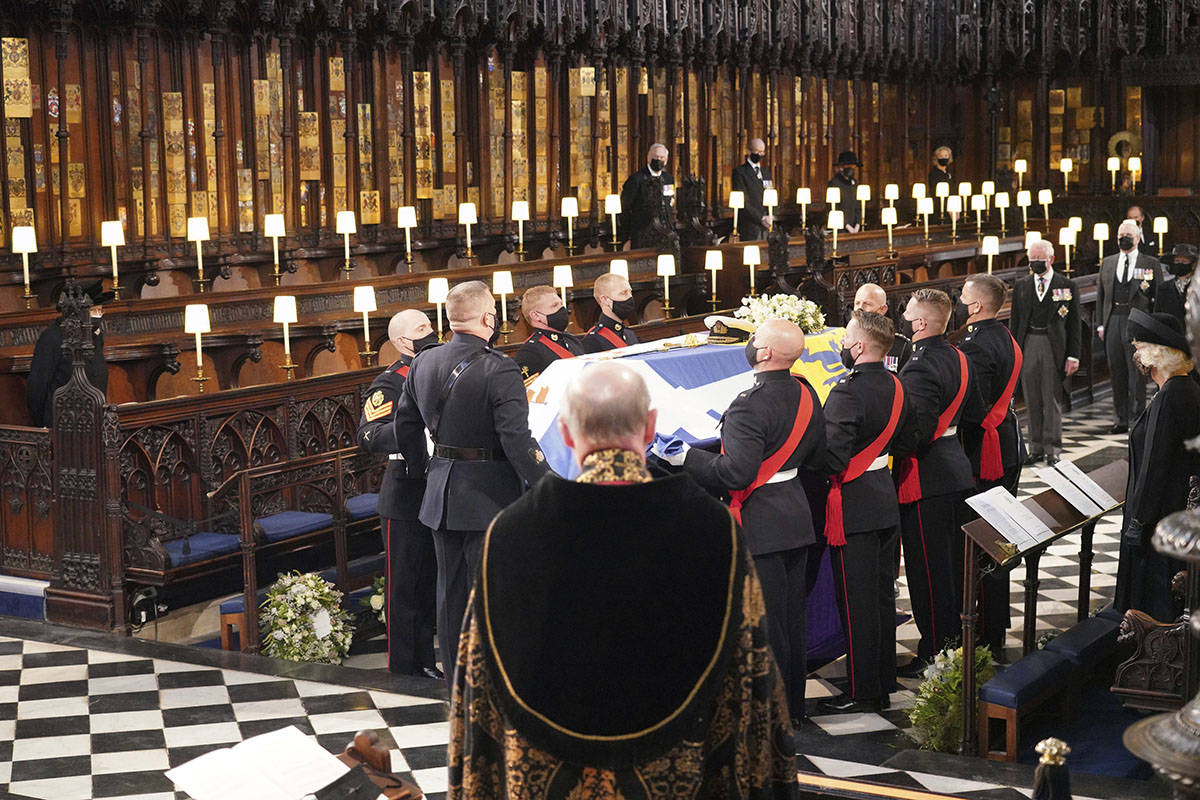 Britain's Queen Elizabeth II, obscured left, looks on the flag draped coffin in St. George&#x20 ...