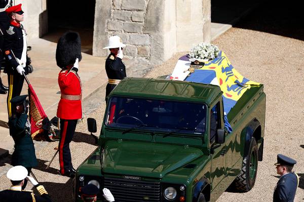 Members of the military salute the coffin of Britain's Prince Philip as it sits atop a modified ...