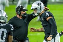 Raiders head coach Jon Gruden comes together on the sidelines with Raiders quarterback Derek Ca ...