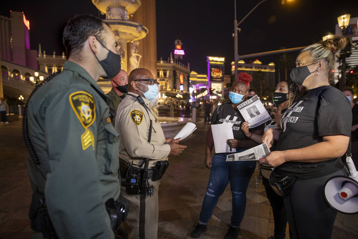 Las Vegas police make contact with organizers before they leave the Venetian to march along the ...