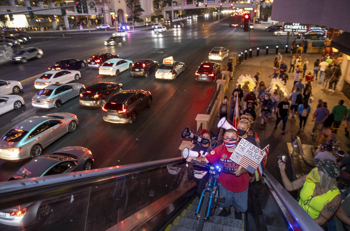 A small group heads up to a pedestrian bridge during a march along the Strip following the conv ...