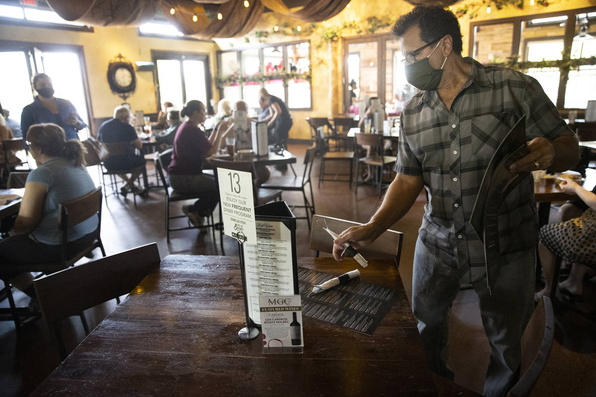 Joe Pierro, owner of Market Grille Cafe, sets up a table for customers. Labor shortages are req ...