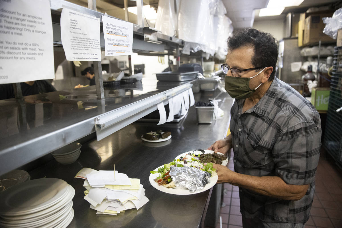 Joe Pierro, owner of Market Grille Cafe, runs food to customers at his restaurant because he is ...