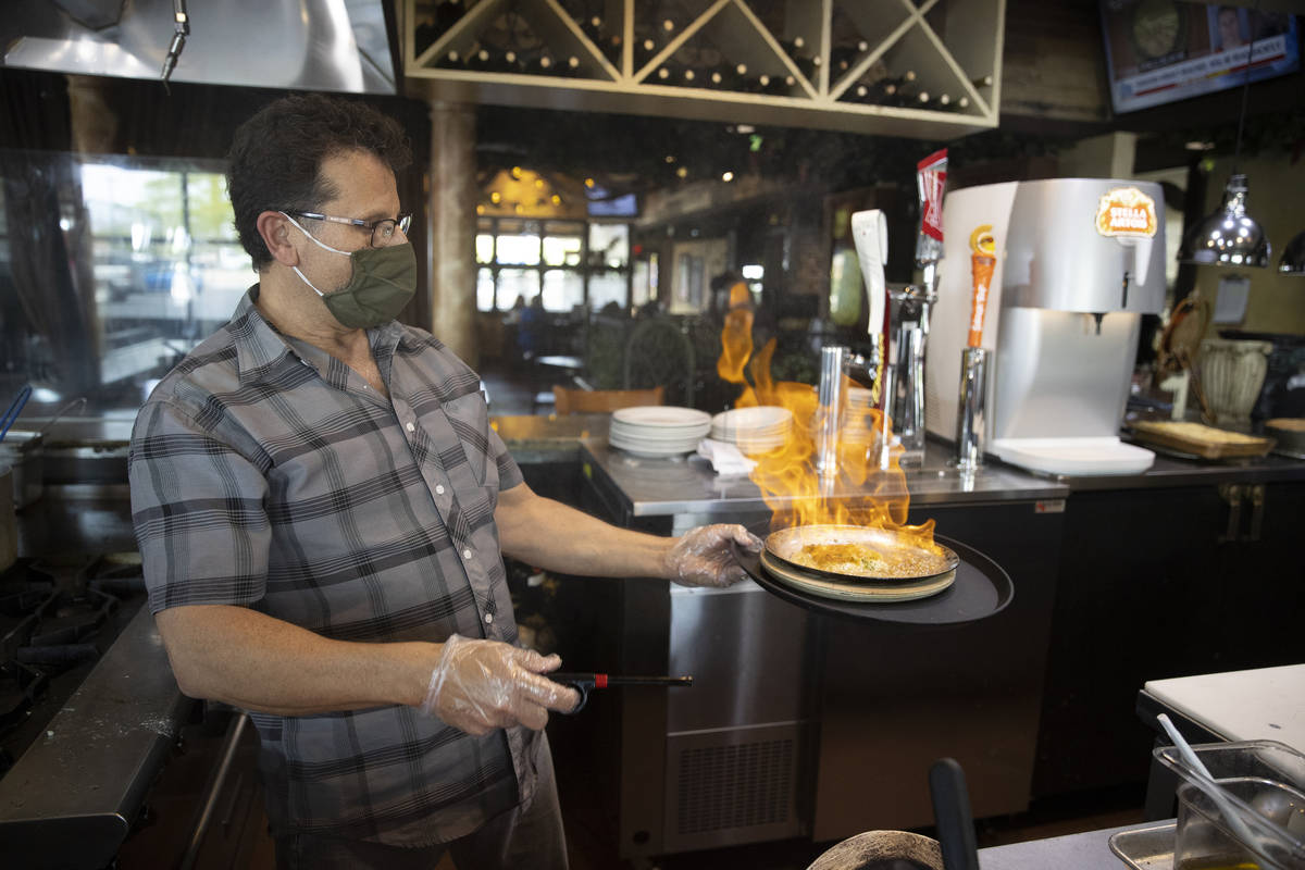 Joe Pierro, owner of Market Grille Cafe, prepares Saganaki at his restaurant. (Erik Verduzco/La ...