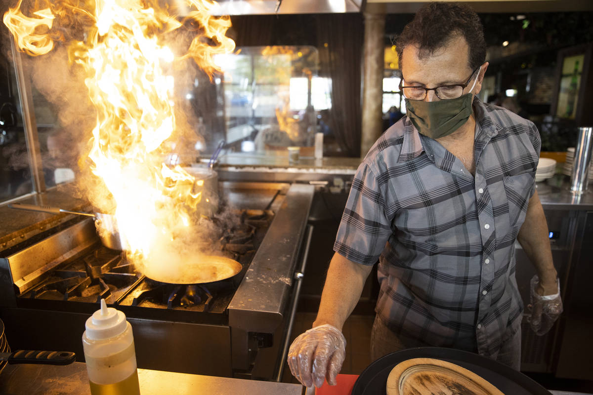 Joe Pierro, owner of Market Grille Cafe, prepares Saganaki, melted cheese, at his N. Durango Dr ...