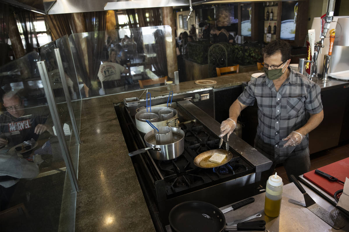 Joe Pierro, owner of Market Grille Cafe, prepares Saganaki at his N. Durango Drive restaurant. ...