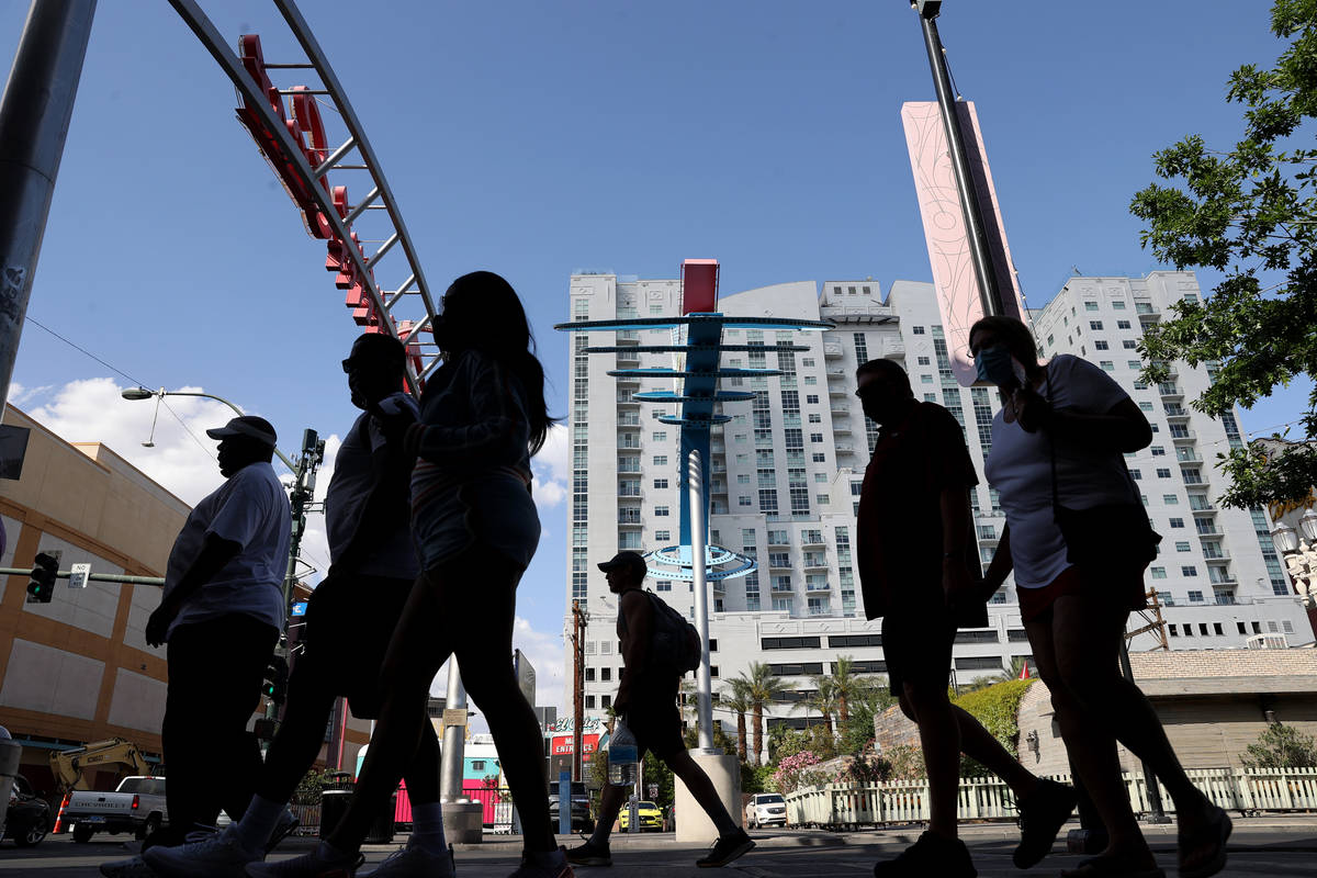 People walk on Fremont Street at Las Vegas Boulevard downtown Wednesday, April 21, 2021. (K.M. ...