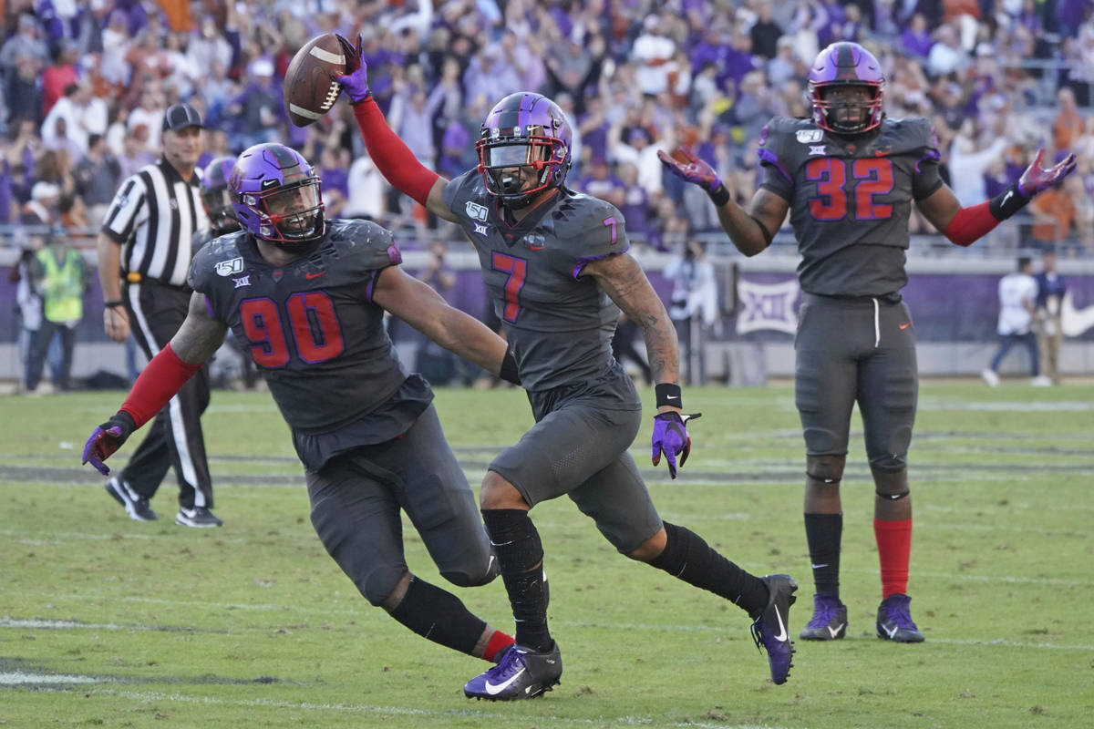 TCU safety Trevon Moehrig (7) celebrates his interception with teammates Ross Blacklock (90) an ...