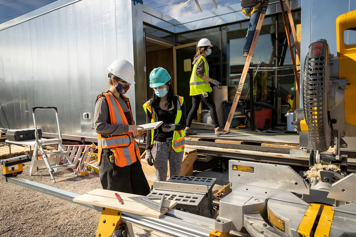 Architecture students Stephanie Cote and Danica Dasmarinas, center, help build Mojave Bloom, a ...