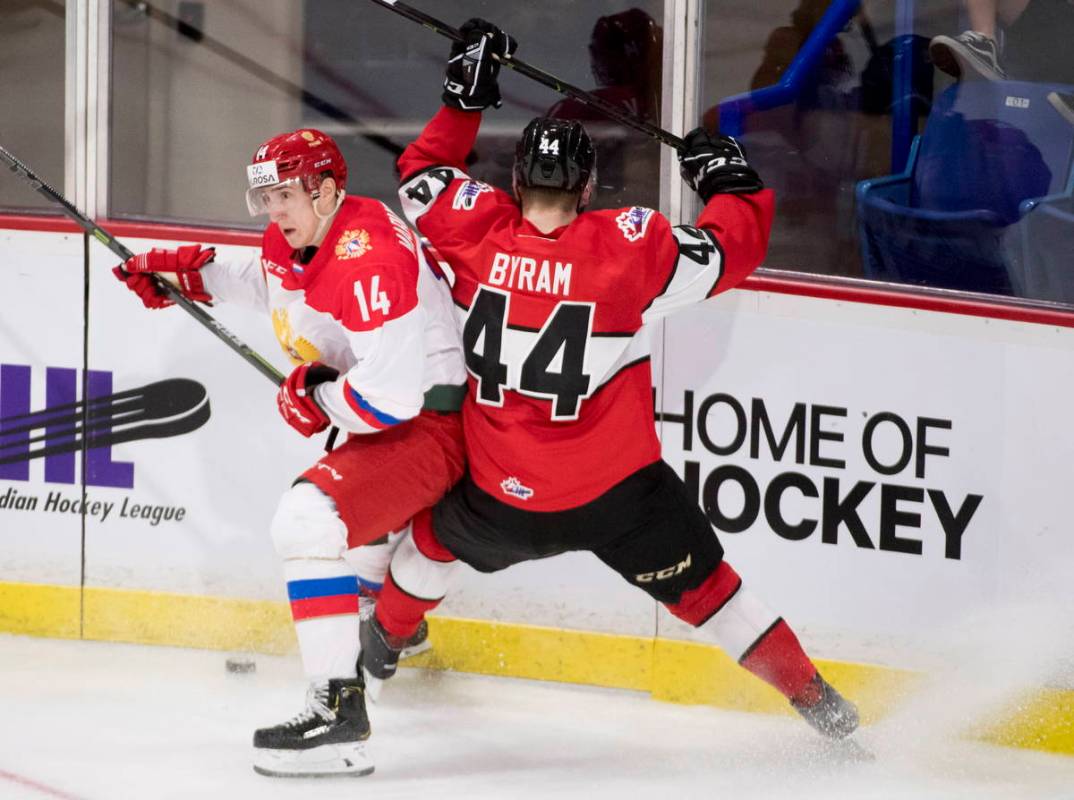 WHL player Bowen Byram fights for control of the puck with Russia's Maxim Marushev during secon ...