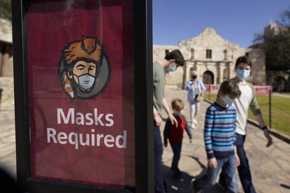 Visitors wearing face masks leave the Alamo, Wednesday, March 3, 2021, in San Antonio. Texas Go ...
