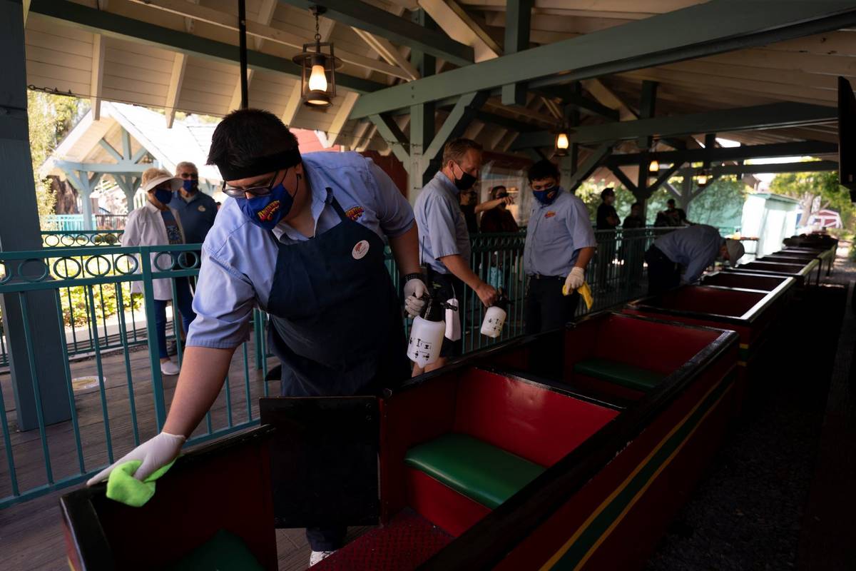 Employees disinfect a train at Adventure City amusement park on the day of reopening in Anaheim ...