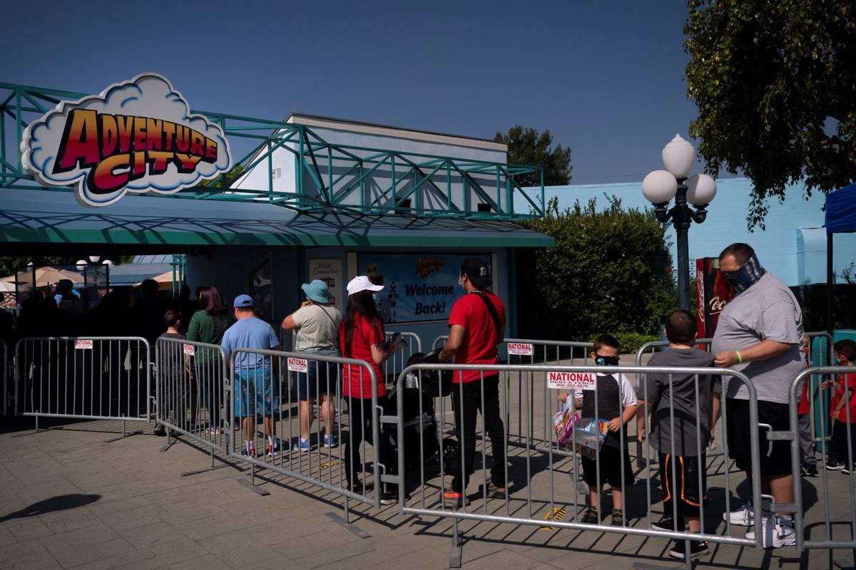 People wait in line to enter Adventure City amusement park on the day of reopening in Anaheim, ...