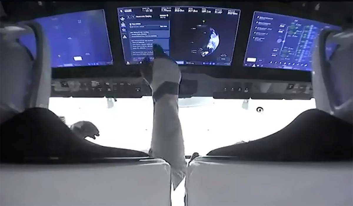 In this image made from NASA video, astronauts are seen in the cockpit of the SpaceX Crew Drago ...