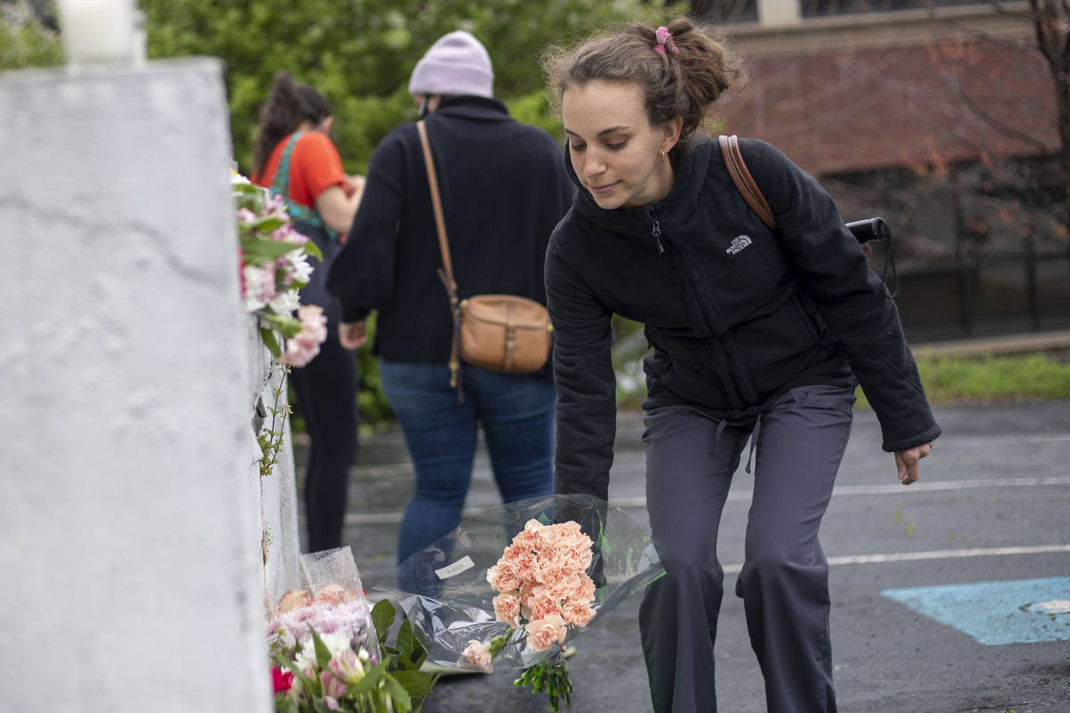 A woman places flowers near a makeshift memorial outside of the Gold Spa in Atlanta, Wednesday, ...