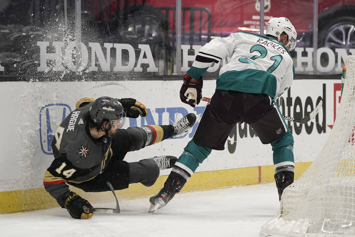 Vegas Golden Knights' Nicolas Hague, left, falls to the ice while fighting for the puck with An ...