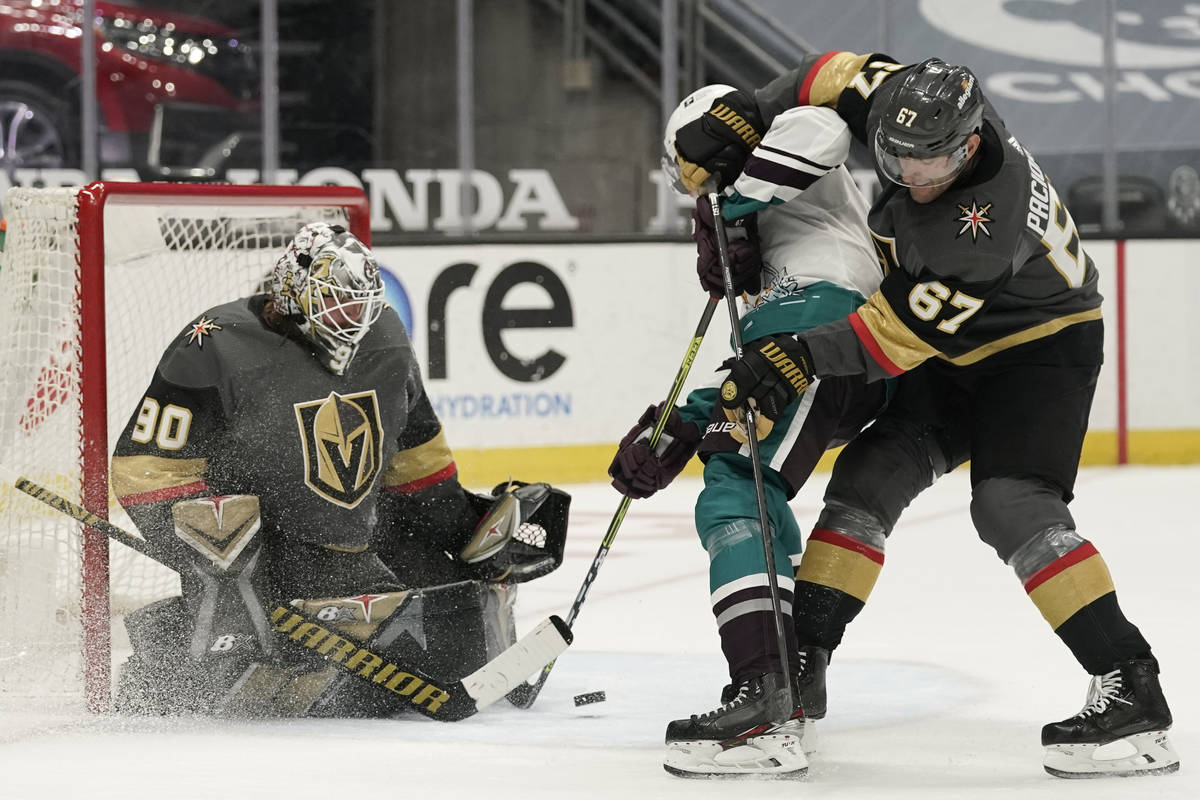 Defended by Vegas Golden Knights' Max Pacioretty, right, Anaheim Ducks' Rickard Rakell, center, ...