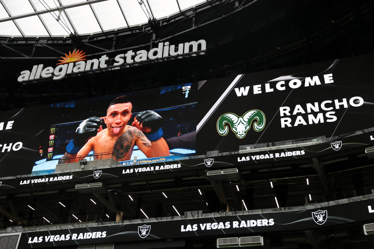 Stadium screens display a welcome message for Rancho's football team during a team practice at ...