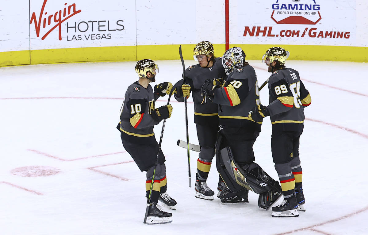 Golden Knights players celebrate with goaltender Robin Lehner after a shootout win against the ...