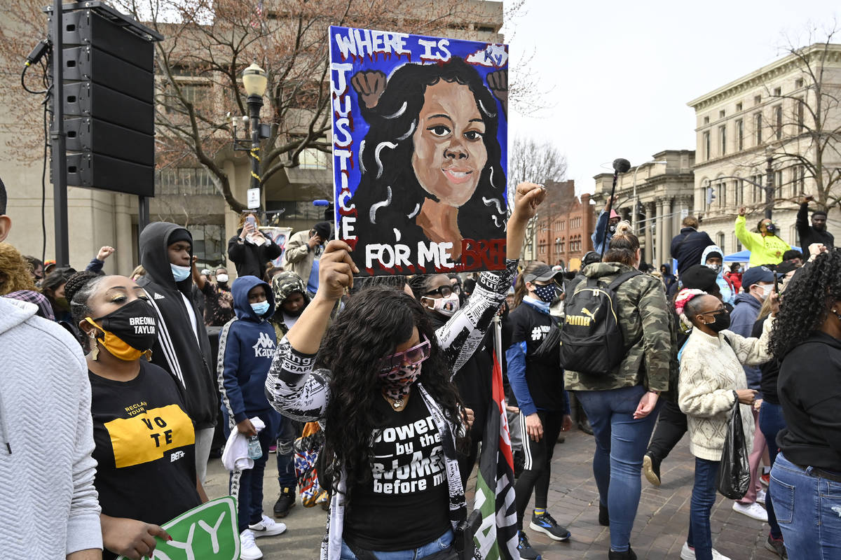 FILE - In this March 13, 2021 file photo, a protester holds up a painting of Breonna Taylor dur ...