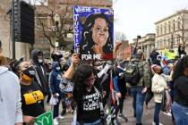 FILE - In this March 13, 2021 file photo, a protester holds up a painting of Breonna Taylor dur ...