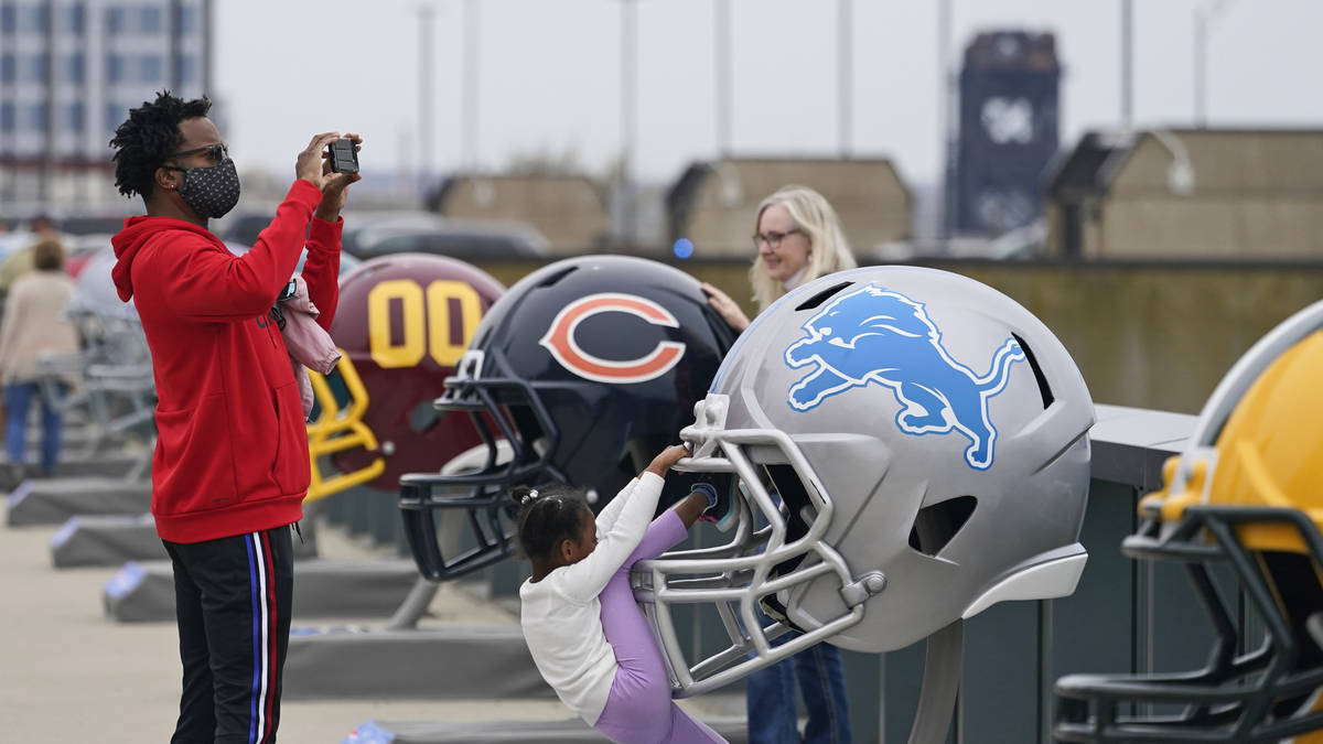 A man takes a picture where 32 teams' helmets are displayed, Saturday, April 24, 2021, in Cleve ...