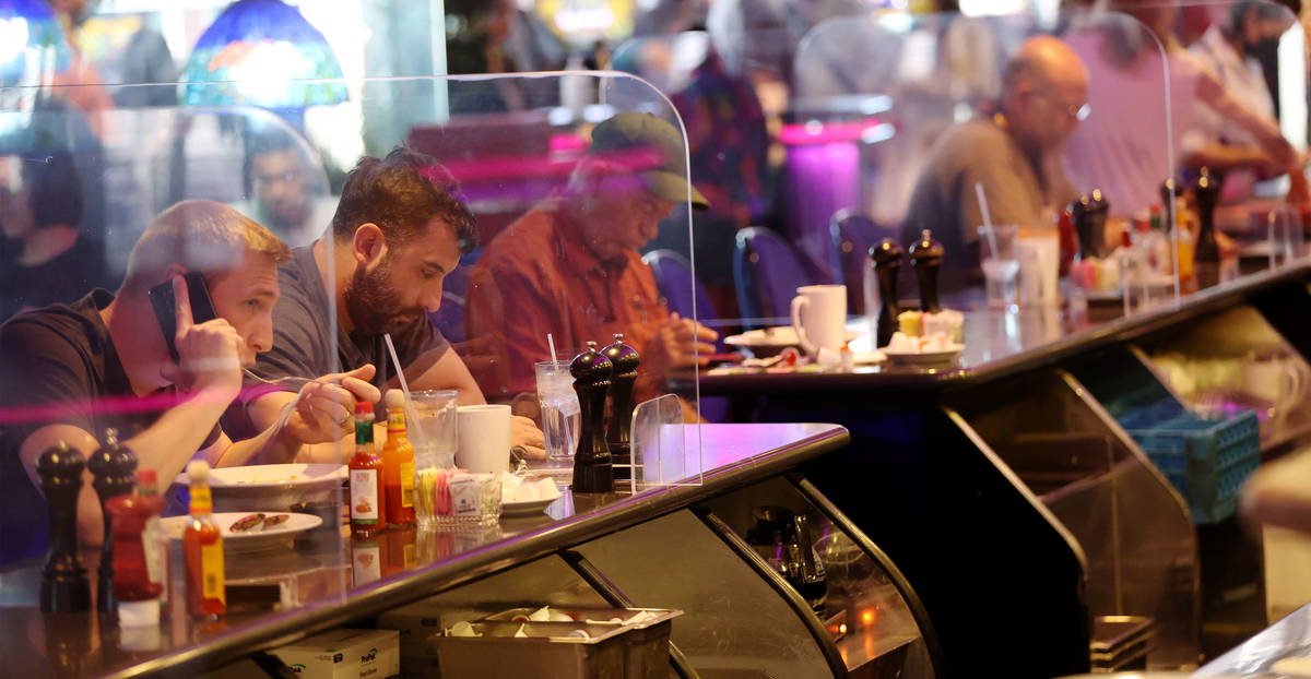 People dine between dividers at the Peppermill restaurant in Las Vegas, Thursday, April 29, 202 ...