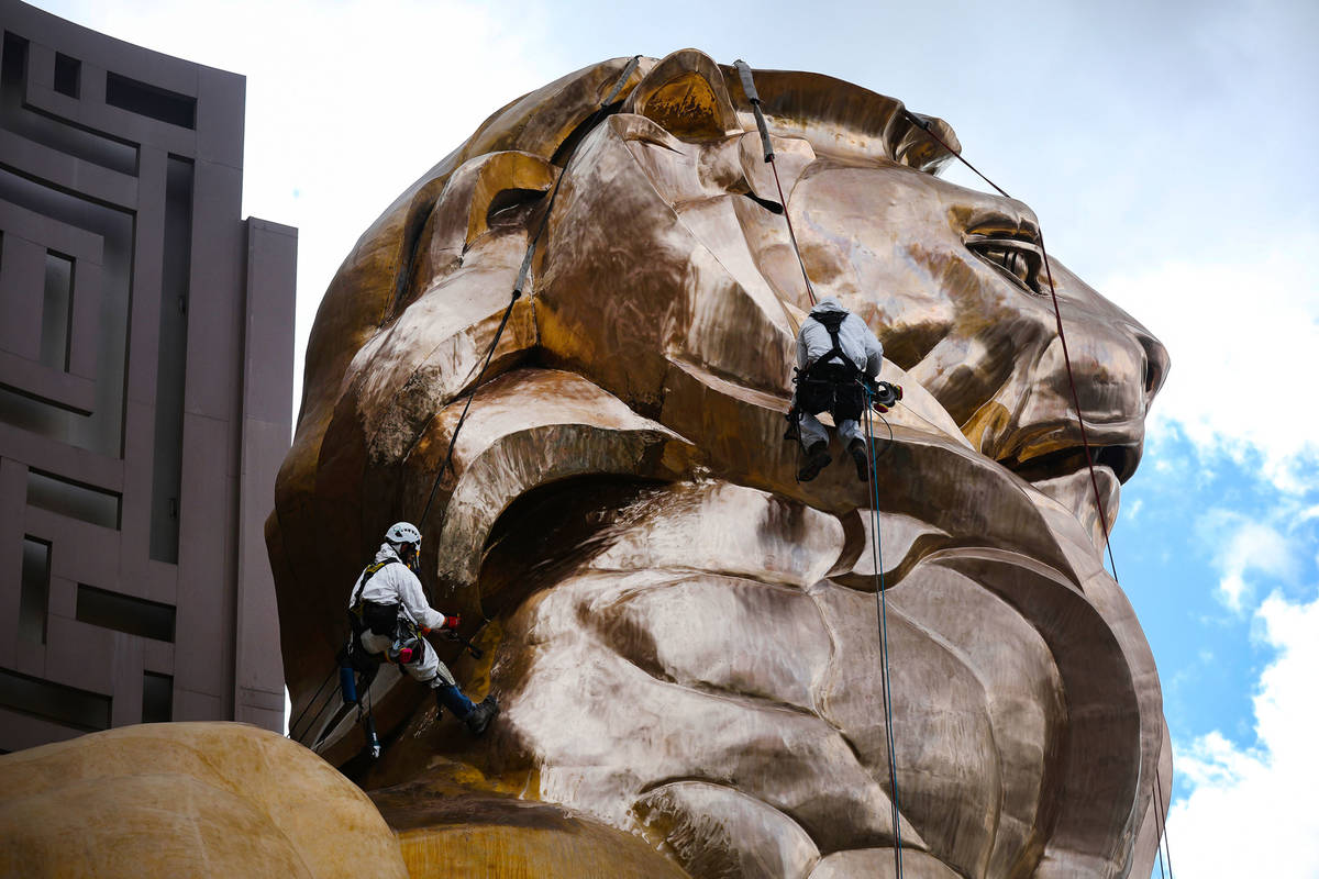 Workers buff the MGM lion statue outside the MGM Grand on Tuesday, April 27, 2021, in Las Vegas ...