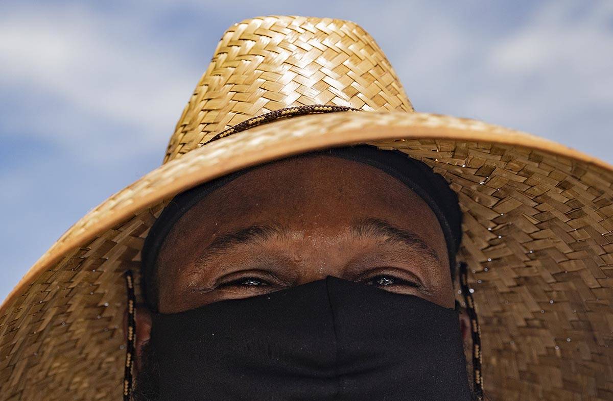 Sweat drips off the brow of Annie's Kitchen pit master Quincy Reynolds as he prepares ribs for ...