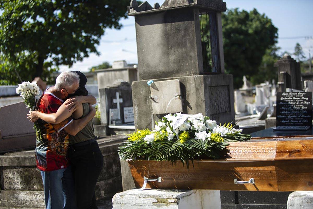 Relatives grieve during the burial service for Monica Cristina, 49, who died from complications ...