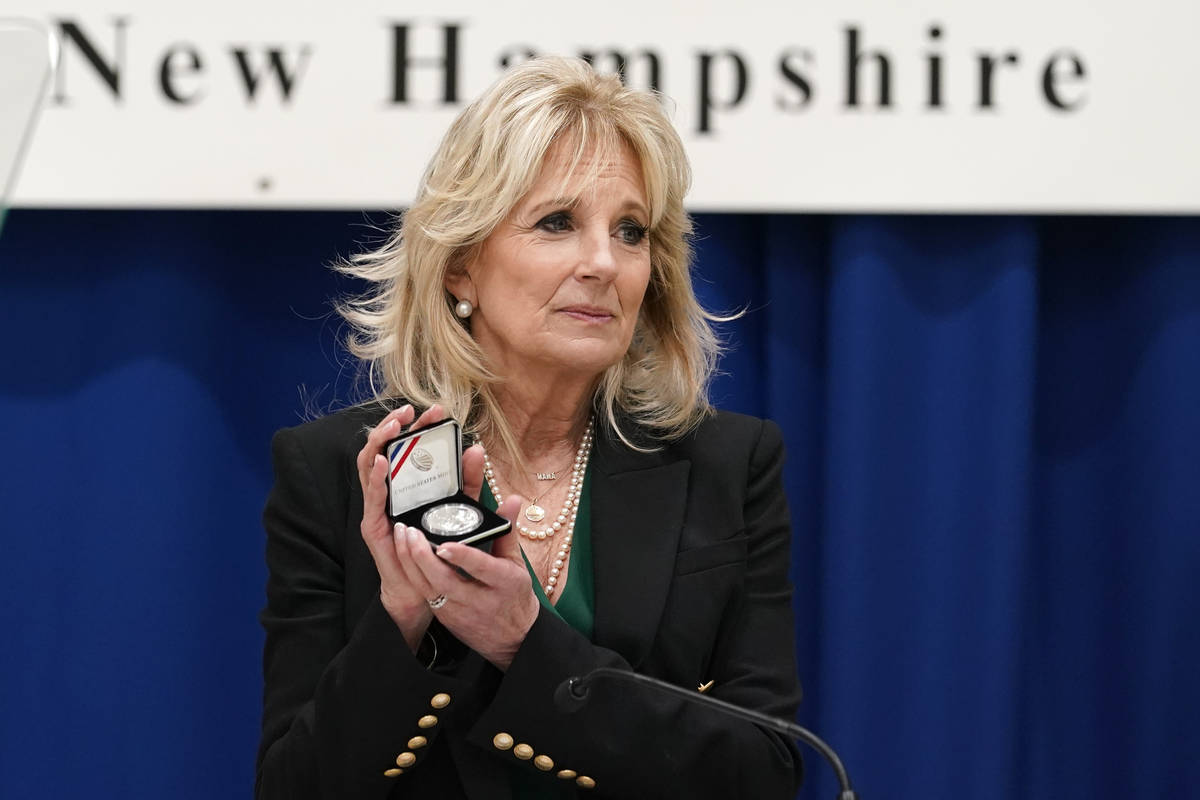 First lady Jill Biden holds a Christa McAuliffe commemorative coin she received as she speaks a ...