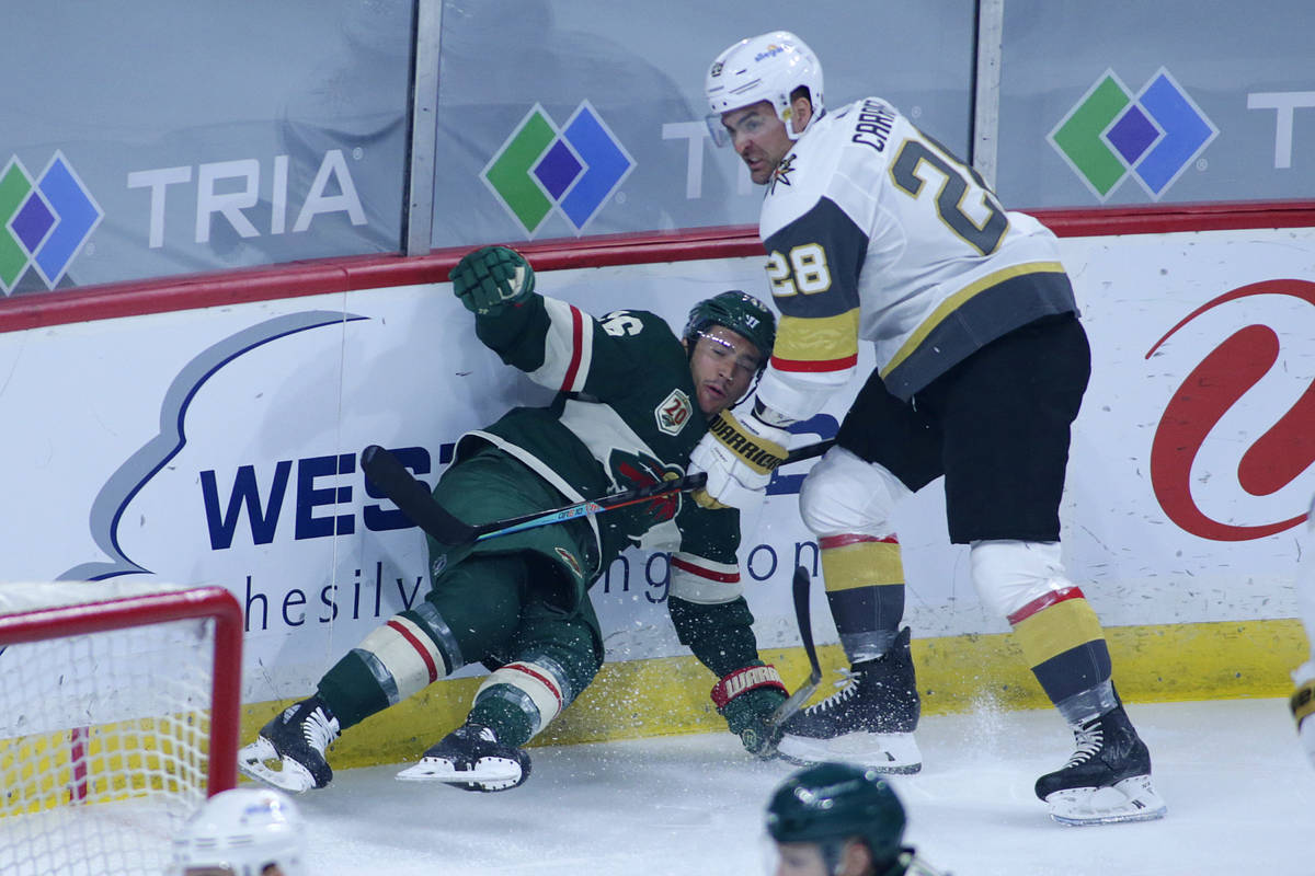 Vegas Golden Knights left wing William Carrier (28) takes down Minnesota Wild defenseman Jared ...