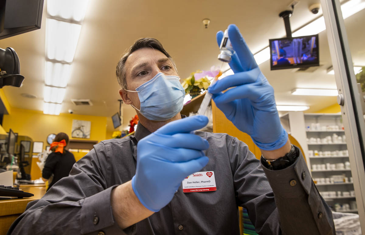 Dan Heller as the Health & Wellness Pharmacy Practice Coordinator draws up a syringe of the Mod ...