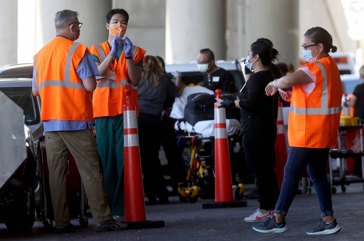 Workers, including Leo Chen, second from left, prepare to give shots during a drive-thru COVID- ...