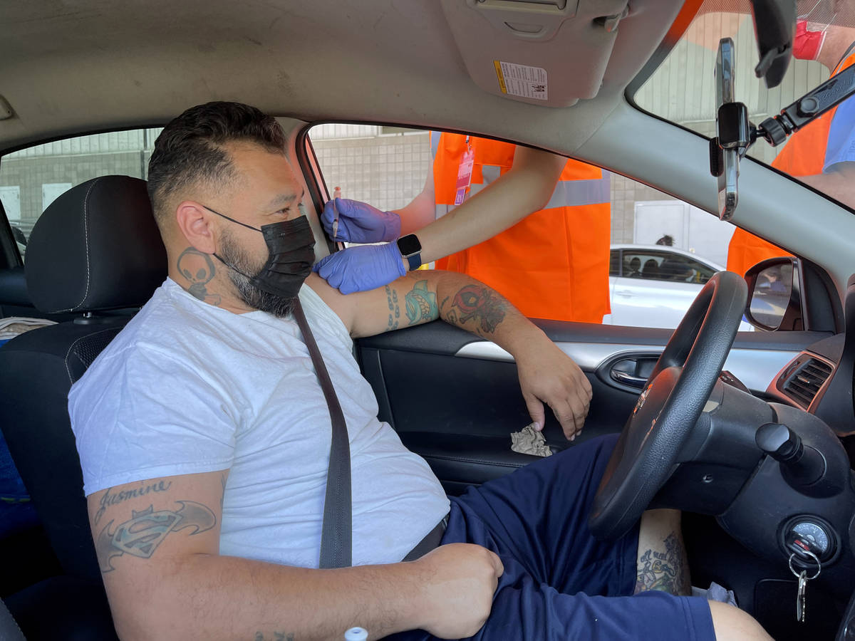 Carlos Montiel of Las Vegas gets his shot during a drive-thru COVID-19 vaccine clinic in the Br ...