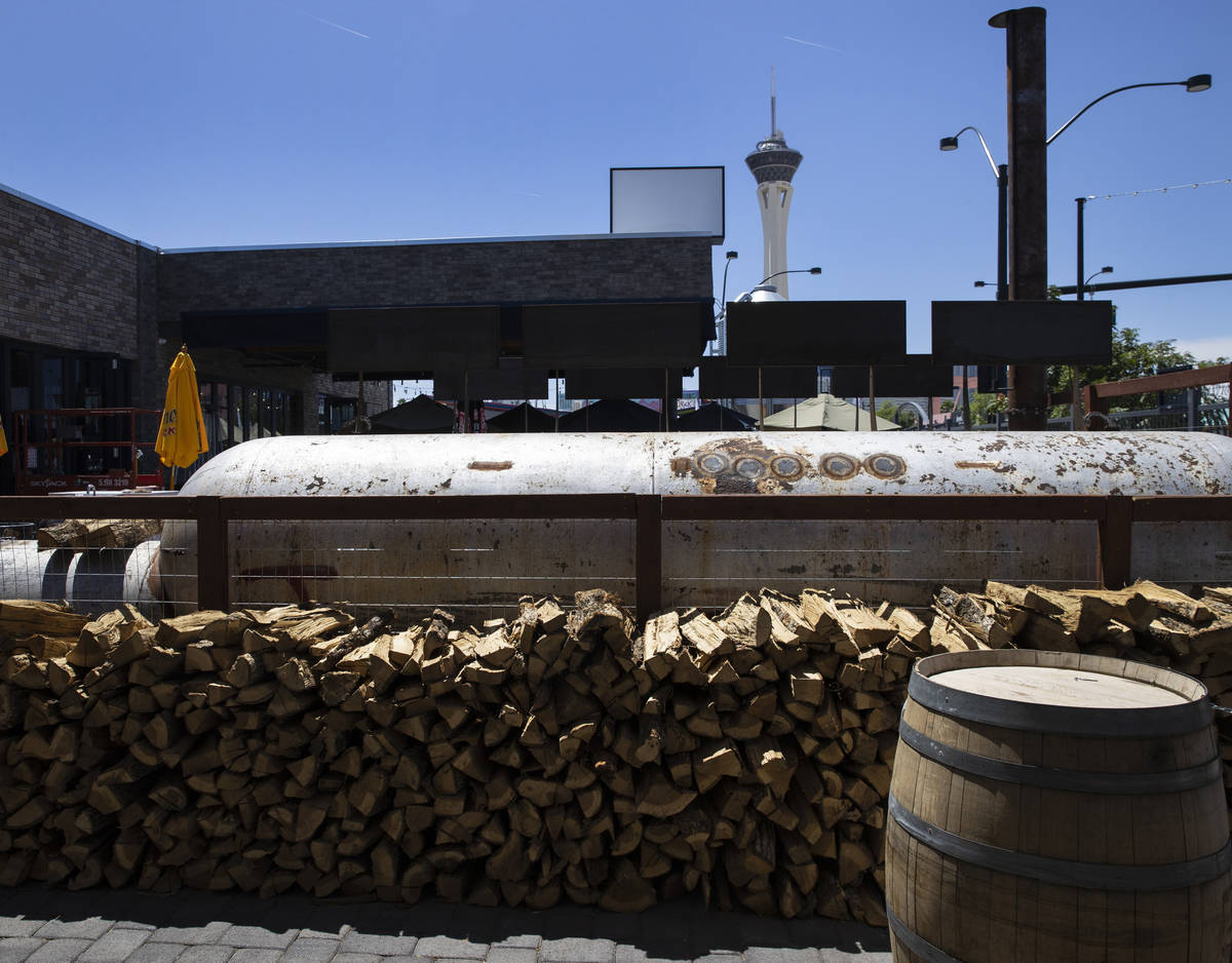 A giant BBQ smoker and smoking woods are shown at Soulbelly BBQ, Arts District BBQ spot, on Tue ...