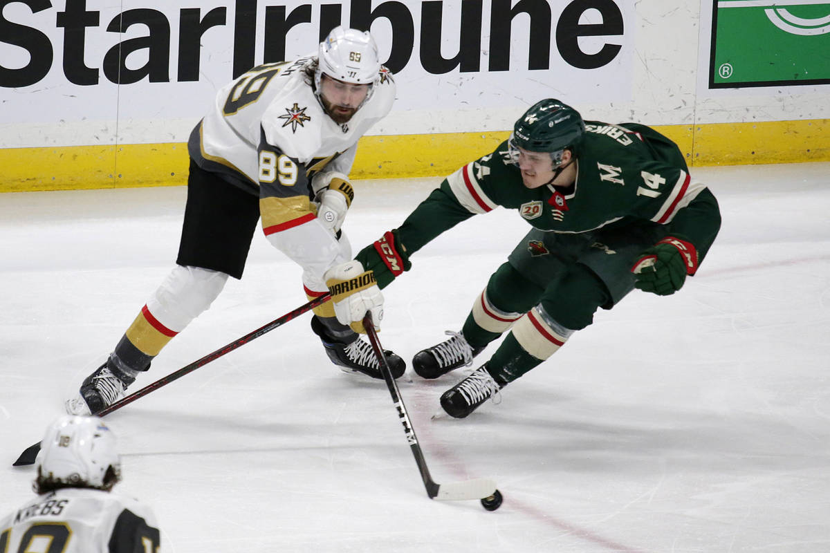 Vegas Golden Knights right wing Alex Tuch (89) controls the puck as Minnesota Wild center Joel ...