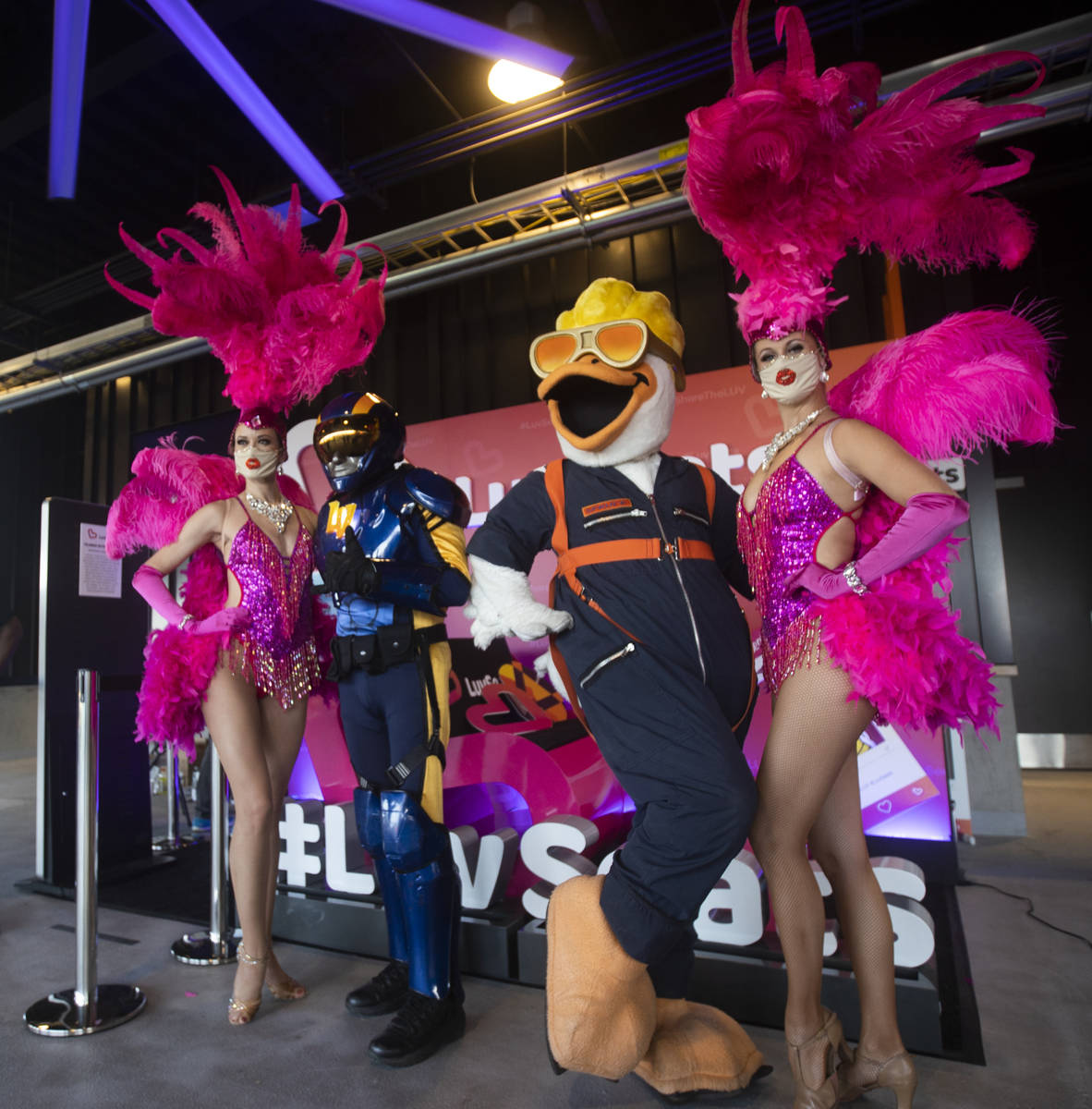Aviator, second from left, and Spruce the Goose pose with showgirls before the start of a Tripl ...