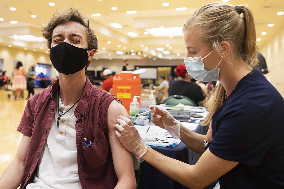 Jared Fessler, left, gets his COVID-19 vaccination from Touro University Nevada physician assis ...