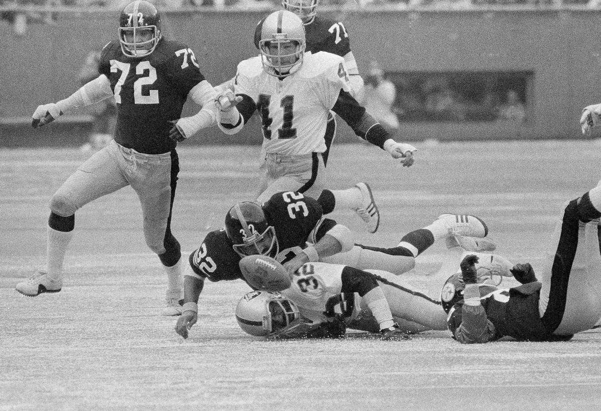 Raiders Jack Tatum, (32) is on the ground as he and Steelers Franco Harris (32) go after the ba ...