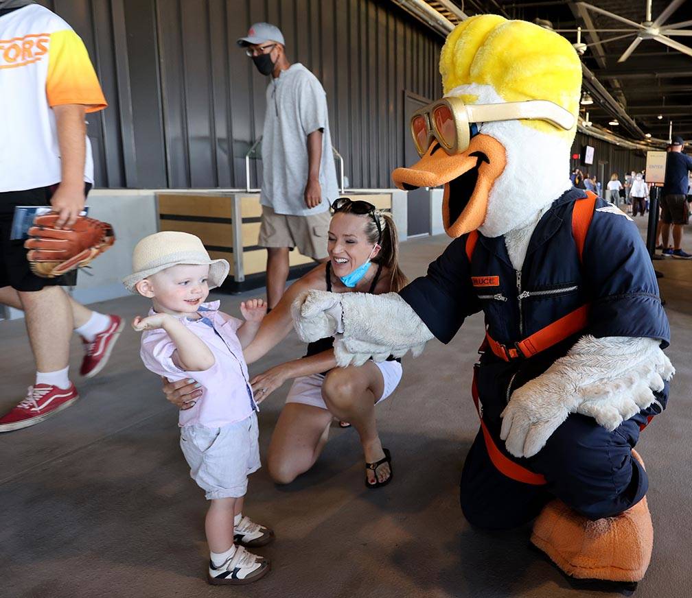 Janel Hansen and her son Ryker greet Spruce the mascot on the concourse at Las Vegas Ballpark a ...