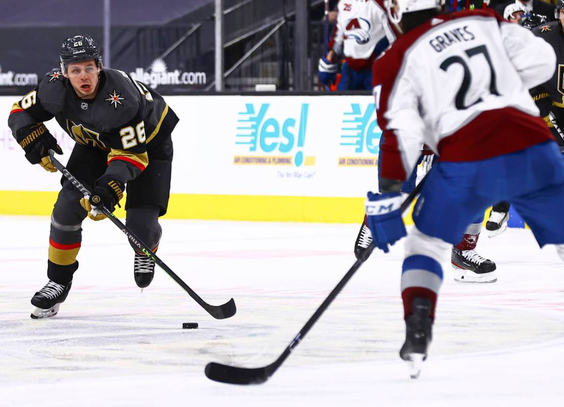 Golden Knights' Mattias Janmark (26) looks to skate past Colorado Avalanche's Ryan Graves (27) ...