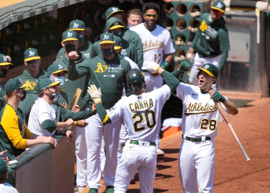 Oakland Athletics' Mark Canha (20) celebrates with Matt Olson (28) after hitting a solo home ru ...