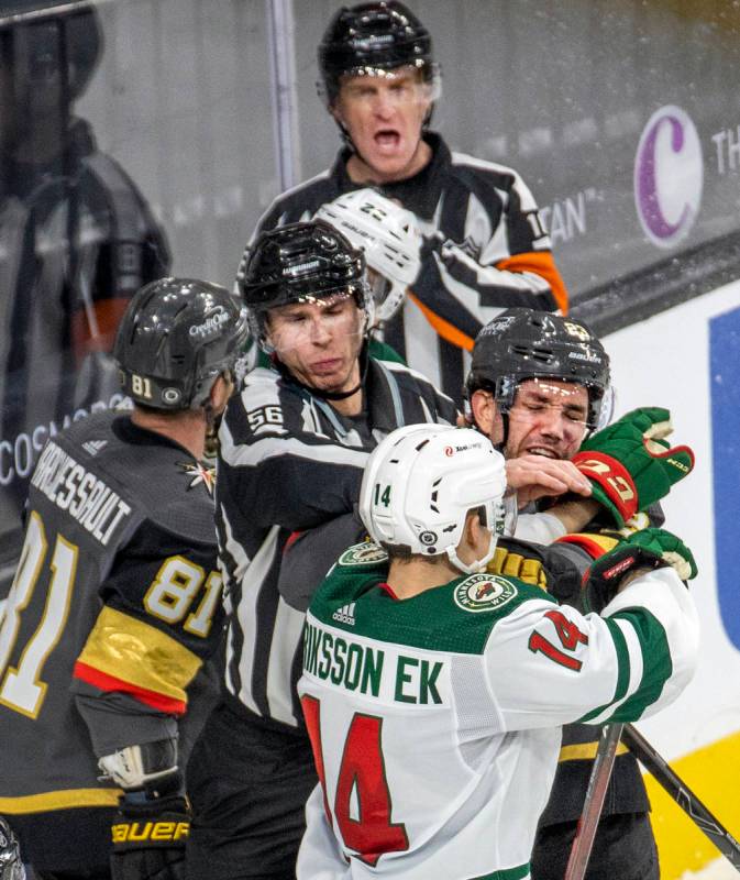 Golden Knights defenseman Alec Martinez (23) and Minnesota Wild center Joel Eriksson Ek (14) ha ...