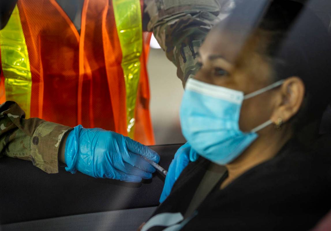 Nevada National Guard PFC Alicia Vavona gives an injection during a preview of the new drive-th ...