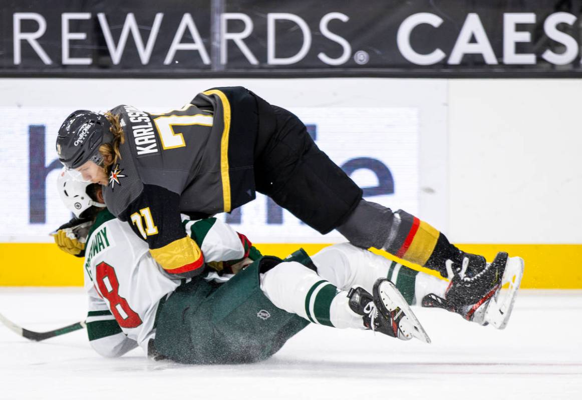 Golden Knights center William Karlsson (71) takes down Minnesota Wild left wing Jordan Greenway ...