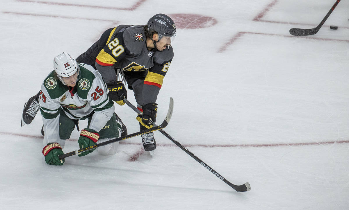 Golden Knights center Chandler Stephenson (20) eyes the puck as he tumbles over Minnesota Wild ...