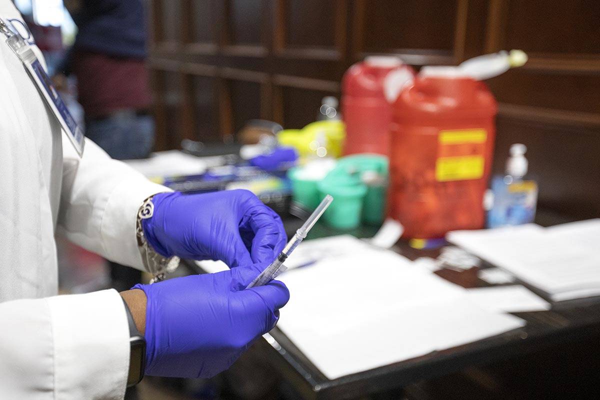 Chika McTier, a registered nurse, prepares a shot during a pop-up COVID-19 vaccine clinic at La ...