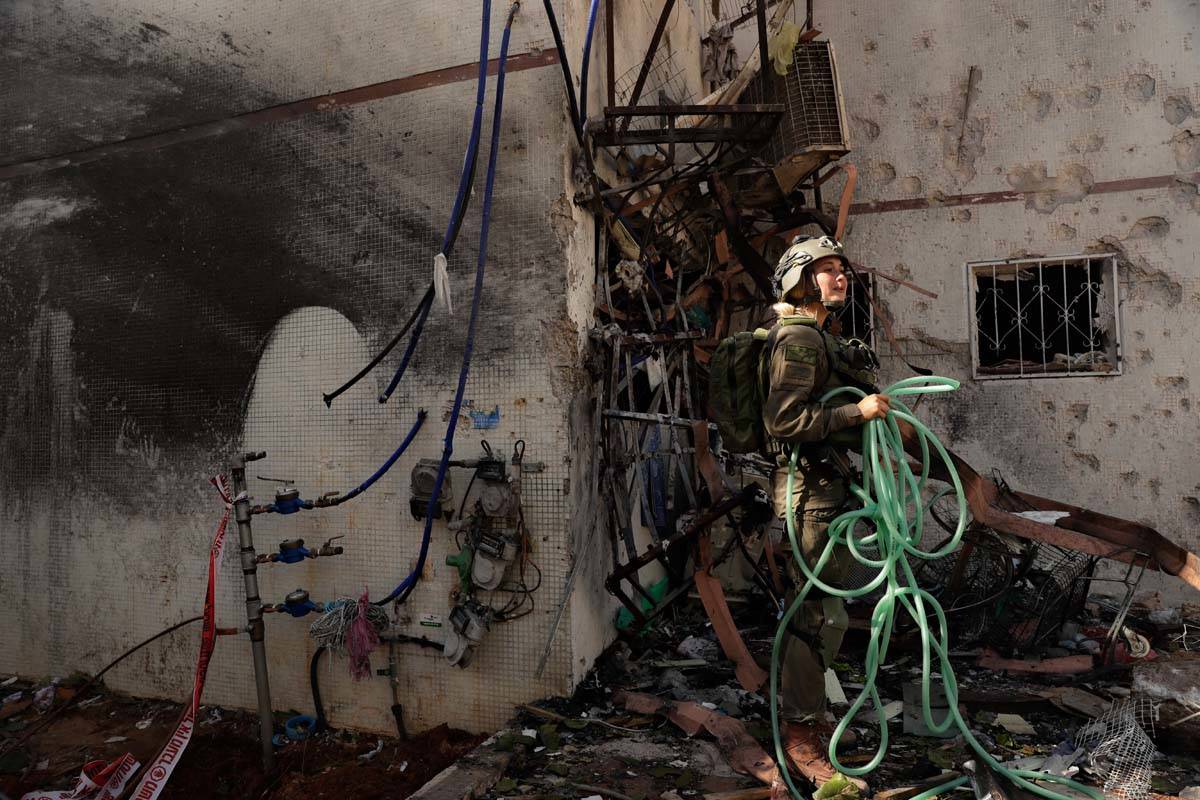 An Israeli soldier inspects damage to an apartment in a residential building after it was hit b ...