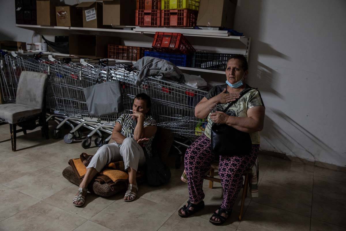Israeli Kassadra Bodari, left, and Lilian Feciouru take shelter in Ashdod, Israel during sirens ...